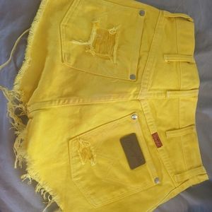Yellow distressed Wrangler shorts